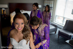 Adorable indian bride helped by bridesmaids to get ready indian bride fashion,indian bride getting ready,indian bridesmaids’ fashion