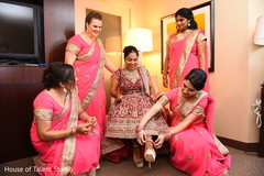Indian bridesmaid helping bride with her shoes indian bride fashion,indian bride getting ready,indian bridesmaids fashion,indian bridesmaids