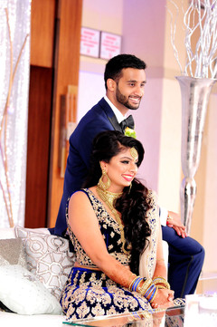 Indian lovebirds posing at their wedding stage. indian wedding reception,wedding cake,indian bride and groom