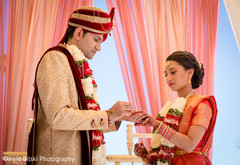 Indian groom putting wedding ring on bride Indian groom putting wedding ring on bride