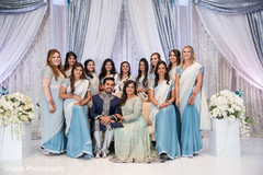 Indian bride and groom posing with bridesmaids during reception indian bride and groom,indian wedding reception,indian bridesmaids,indian wedding reception floral and decor