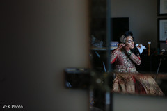 Indian bride putting earring on indian bride,indian bride getting ready,bridal jewelry