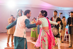 Joyful indian bride and groom dancing during sangeet Joyful indian bride and groom dancing during sangeet