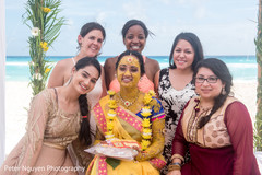 Indian bride covered in yellow tumeric paste posing with bridesmaids pre- wedding celebrations,haldi ceremony,indian bride