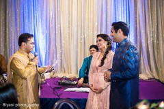 Indian bride and groom listening to speech indian wedding reception,pre-wedding reception photography,indian bride and groom