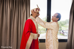 Father helping indian groom getting ready indian groom,getting ready,beige sherwani