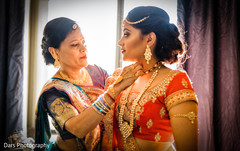 Indian bride's mother helping daugher getting ready bridal jewelry,indian bride getting ready,indian bride lengha