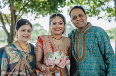 Indian bride posing with her parents indian bride lengha,indian bride portrait,indian bridal bouquet,bridal jewelry