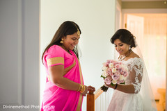 Indian bride and bridesmaid looking at bridal bouquet Indian bride and bridesmaid looking at bridal bouquet