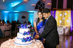 Glowing indian couple cutting the cake indian wedding reception,indian wedding reception photography,indian bride and groom,indian wedding cake
