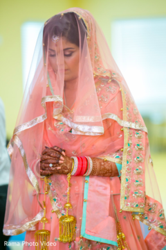 Sweet indian bride praying during the wedding ceremony peach bridal lengha,peach lengha,bridal fashion