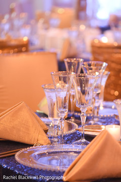 Tables covered with beautiful lux linens in sequined blue and gold indian wedding floral and decor,indian wedding rentals,indian wedding decor