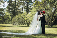 Emotional maharani hugging the groom indian bride fashion,white wedding dress,red bridal bouquet