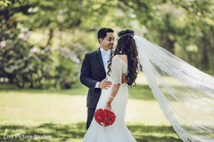 Candid indian couple portrait red bridal bouquet,indian bride fashion,indian groom suit