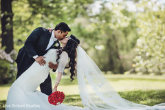 Sweet indian couple kissing white wedding dress,indian groom fashion,indian bride fashion