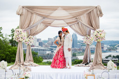 Enchanting indian bride and groom posing under mandap ndian bride lengha,indian groom fashion,mandap,indian wedding ceremony floral and decor
