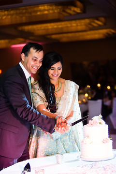 Indian bride and groom's cutting the cake moment indian wedding reception,indian bride and groom,indian wedding reception photography,indian wedding cake