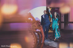 Upbeat indian couple making their entrance to wedding reception indian wedding reception,indian wedding reception photography,indian bride and groom