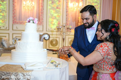 Adorable indian couple cutting the cake indian wedding reception,indian wedding reception photography,indian bride and groom,indian wedding cake