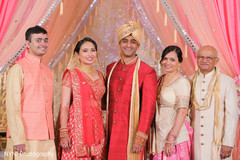 Indian bride and groom posing with family Indian bride and groom posing with family