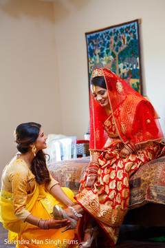 Indian bridesmaid helping bride getting ready Indian bridesmaid helping bride getting ready