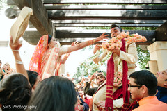Indian bride and groom being lifted up during baraat Indian bride and groom being lifted up during baraat