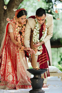 Glamorous indian couple making offerings to sacred fire Glamorous indian couple making offerings to sacred fire