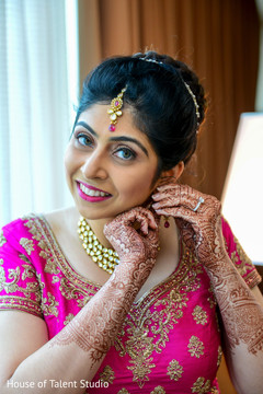 Sweet indian bride putting earrings on Sweet indian bride putting earrings on