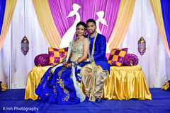 Indian lovebirds vibrant looks. garba celebration,floral and decor,draped stage,indian bride and groom