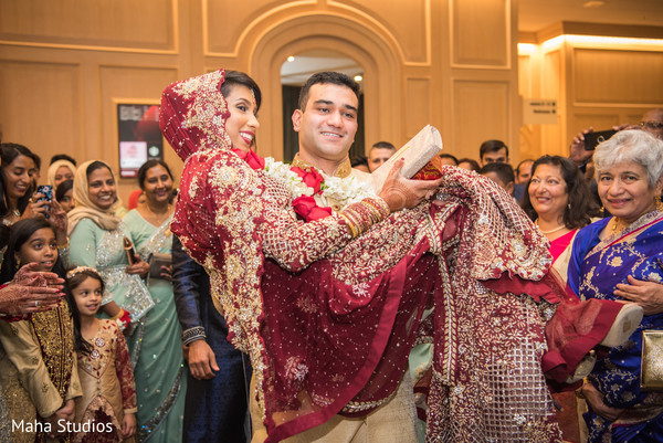 Indian bride being lifted up by groom