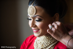 Indian bride putting earrings on Indian bride putting earrings on