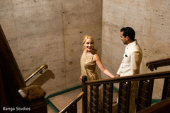 Indian bride and groom walking down the stairs holding hands Indian bride and groom walking down the stairs holding hands