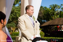 Indian groom's first look of his bride walking down the aisle.