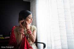 Indian bride putting earrings on Indian bride putting earrings on