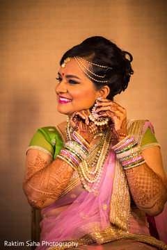 Indian bride putting earrings on Indian bride putting earrings on