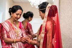 Indian bride's mother helping her to get ready Indian bride's mother helping her to get ready