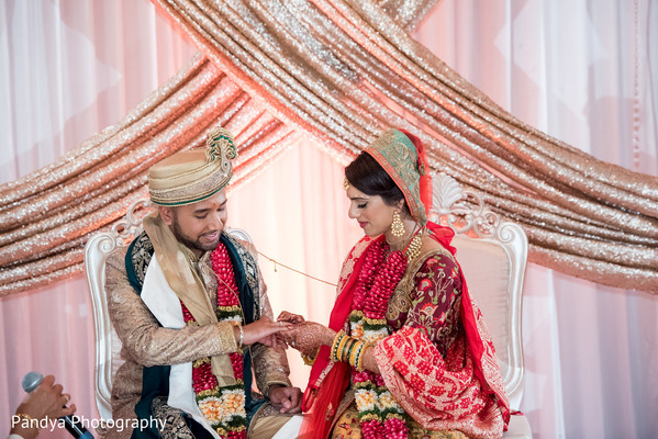 Indian bride putting wedding ring on groom