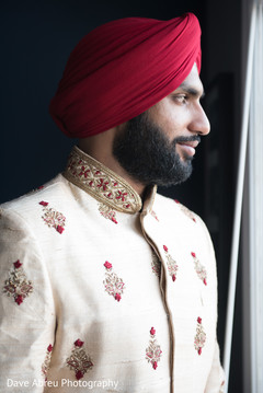 Charming indian groom looking out the window Charming indian groom looking out the window
