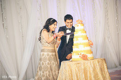 Happy indian bride and groom cutting wedding cake Happy indian bride and groom cutting wedding cake