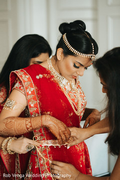 Indian bride being helped to get ready Indian bride being helped to get ready