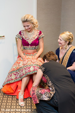 Indian bride being helped with shoes indian wedding gallery,indian bride getting ready,indian bride fashion,bridal shoes