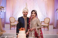Indian lovebirds posing with wedding cake Indian lovebirds posing with wedding cake