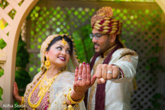 Lovely indian couple showing their wedding rings Lovely indian couple showing their wedding rings