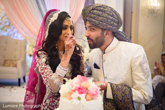 Indian bride giving the groom a taste of wedding cake. indian bride and groom,indian wedding cake,indian wedding celebration,indian wedding fashion