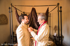 Joyful Indian groom being helped getting ready for his wedding. Joyful Indian groom being helped getting ready for his wedding.