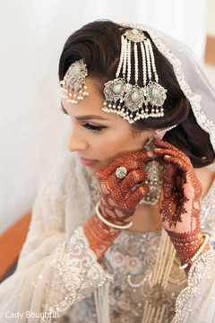 Indian bride putting earrings on Indian bride putting earrings on