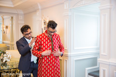 Indian groom being helped to get his sherwani. Indian groom being helped to get his sherwani.