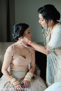 Adorable indian bride being helped with jewelry Adorable indian bride being helped with jewelry