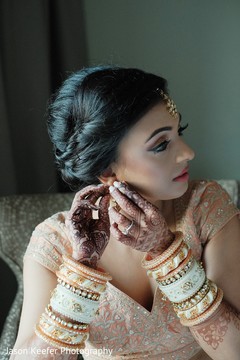 Dazzling indian bride putting earrings on Dazzling indian bride putting earrings on