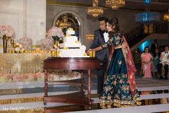 Lovely capture Indian bride and groom cutting cake. indian bride and groom,indian wedding reception fashion,indian wedding cake